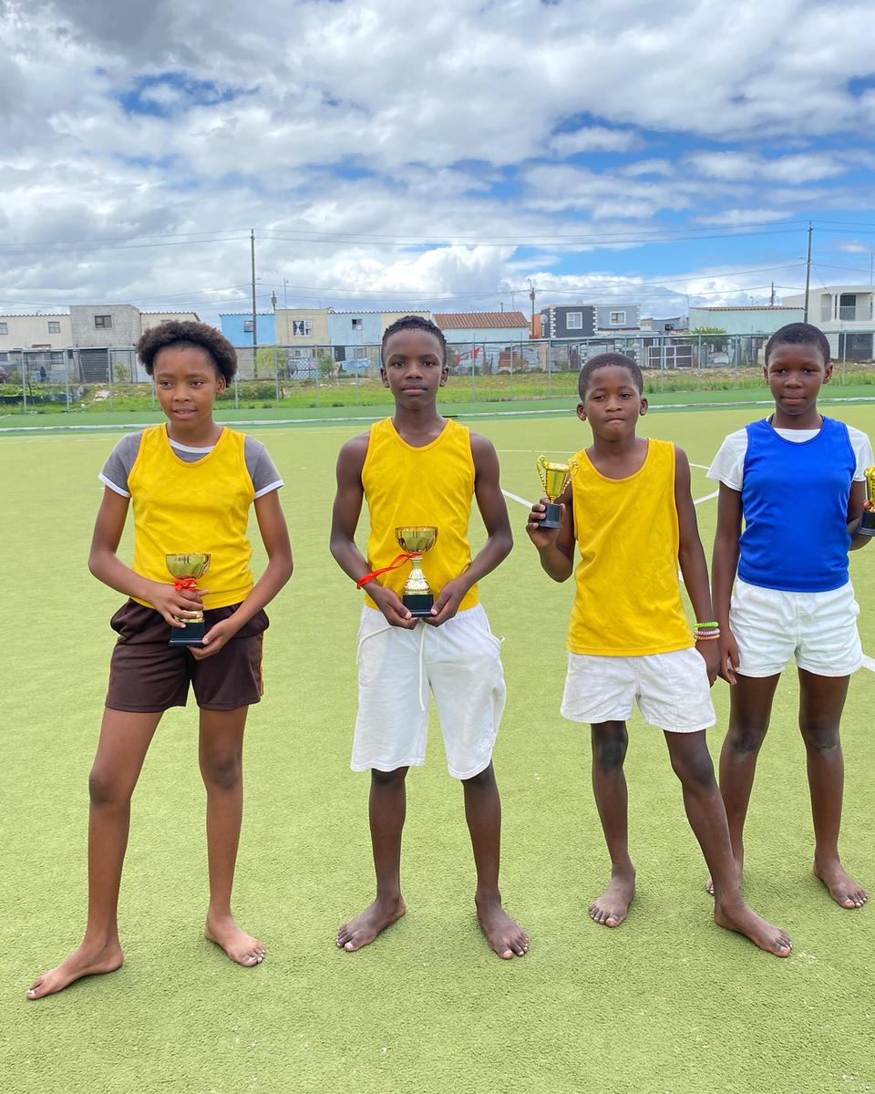 Young athletes with their trophies on the school sports field