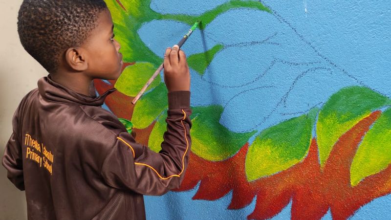 A learner painting the school mural